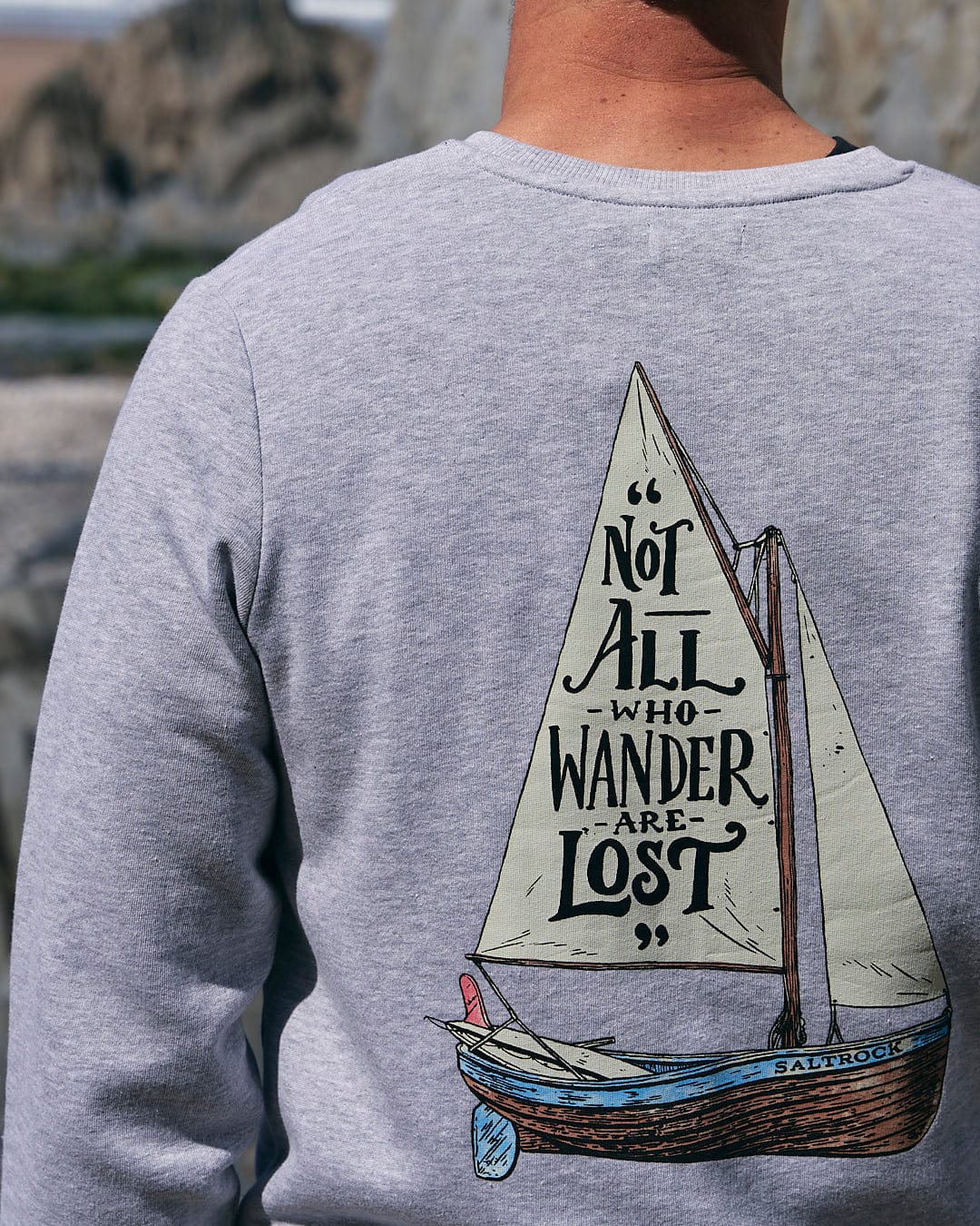 A man wearing a Saltrock sweatshirt with the Lost Ships - Mens Crew Sweat - Grey on it.