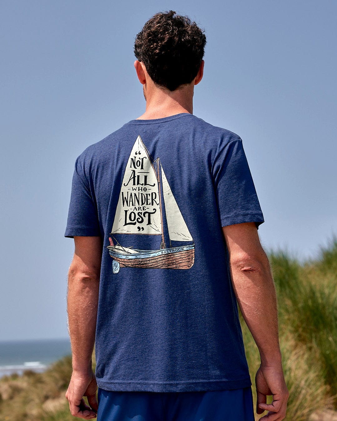 The back of a man wearing a Saltrock Lost Ships Mens Short Sleeve T-Shirt in Blue.