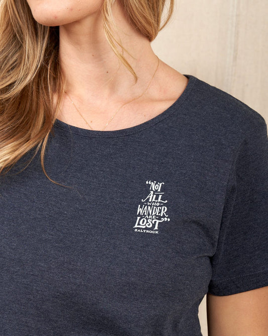 A person wears a blue "Lost Ships" T-shirt by Saltrock, 100% cotton, boasting the phrase "Not all who wander are lost." This comfortable and durable tee is machine washable, perfect for adventurous spirits.