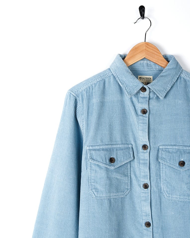 A Saltrock branded Maddox - Womens Cord Shirt - Light Blue with buttoned cuffs, hanging on a hanger.