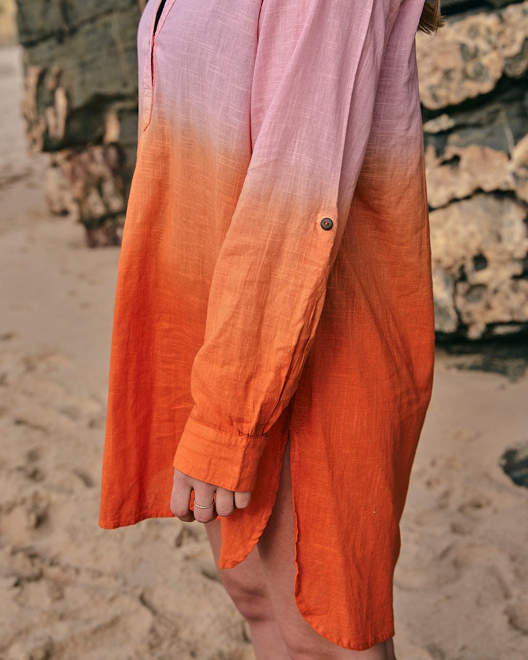A woman wearing a Saltrock Manina - Womens Dip Die Beach Shirt - Orange on the beach.