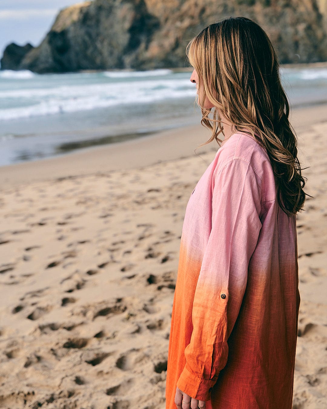A woman wearing a Saltrock Manina - Womens Dip Die Beach Shirt - Orange on the beach.