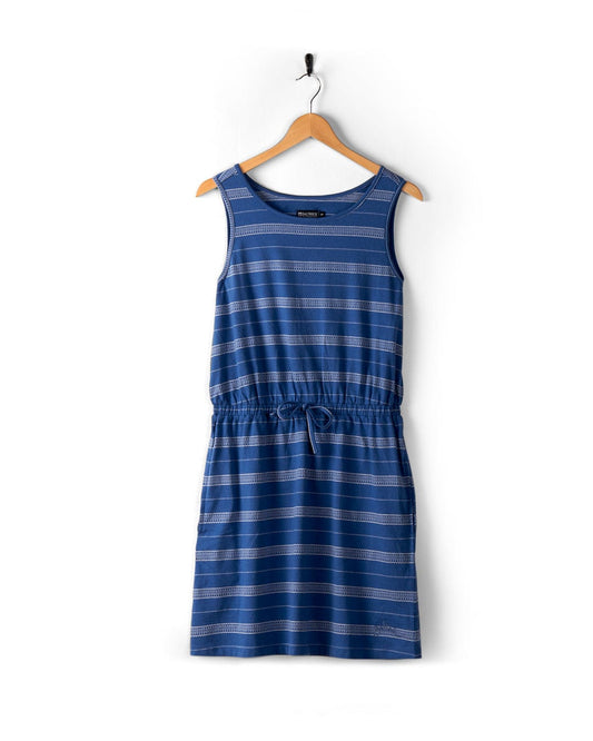 A Marina Bauhaus - Womens Dress - Blue by Saltrock hangs on a wooden hanger against a white background.