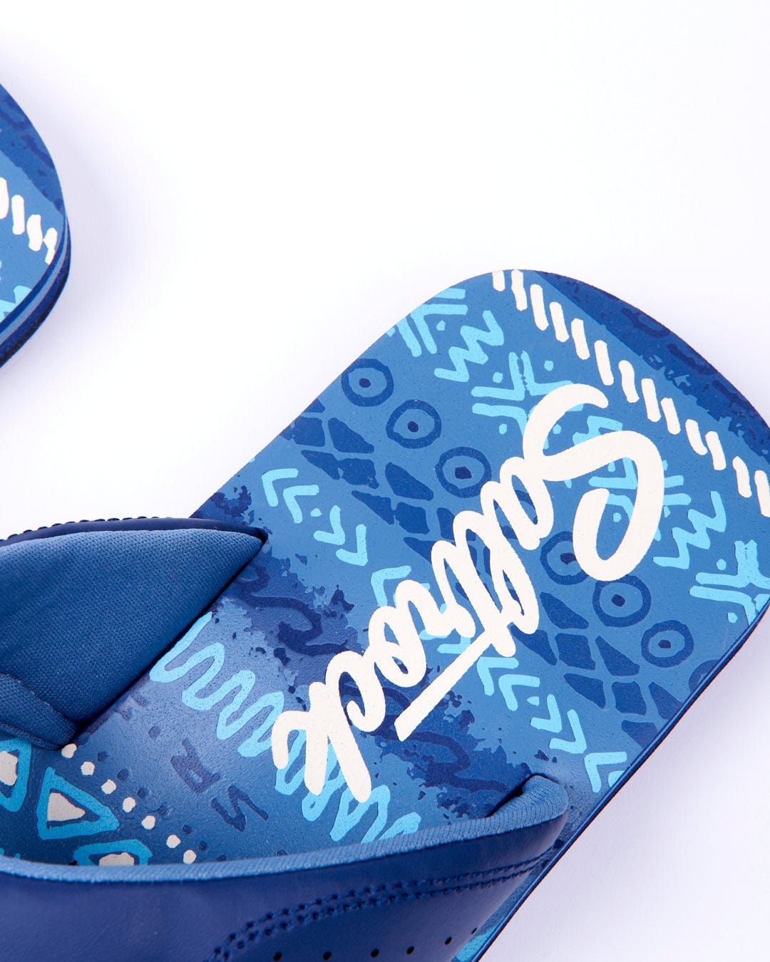 Close-up of a blue Marks - Mens flip-flop with an all-over print and the Saltrock brand name visible on the insole.