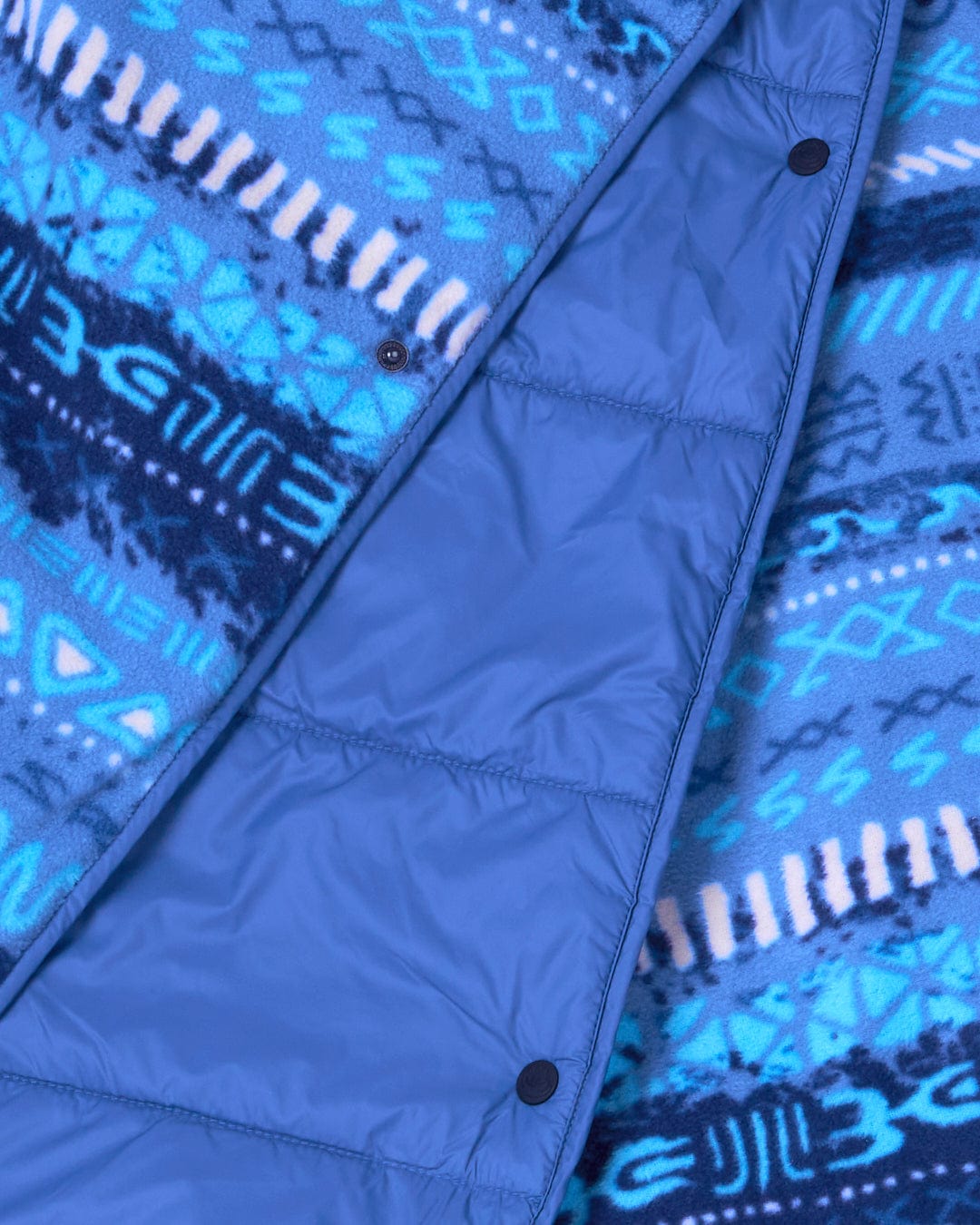 A close up of a Saltrock Marks - Unisex Recycled Reversible Poncho - Blue with a reversible hood and water resistant features.