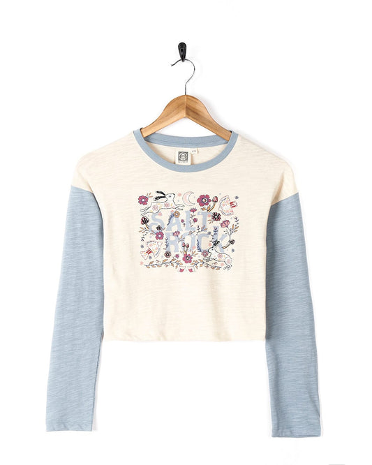 A comfortable women's cropped t-shirt with embroidered floral Meadow - Kids Long Sleeve Cropped T-Shirt - Cream Saltrock branded graphic.