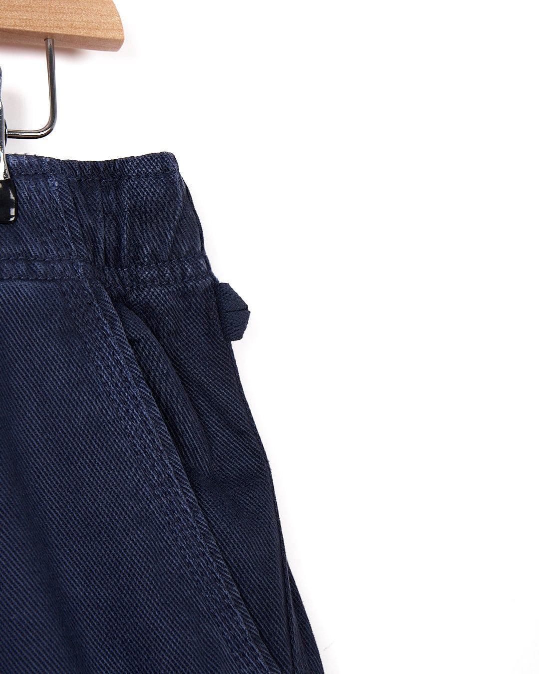 A pair of Meddon - Mens Twill Trouser - Navy shorts hanging on a hanger.