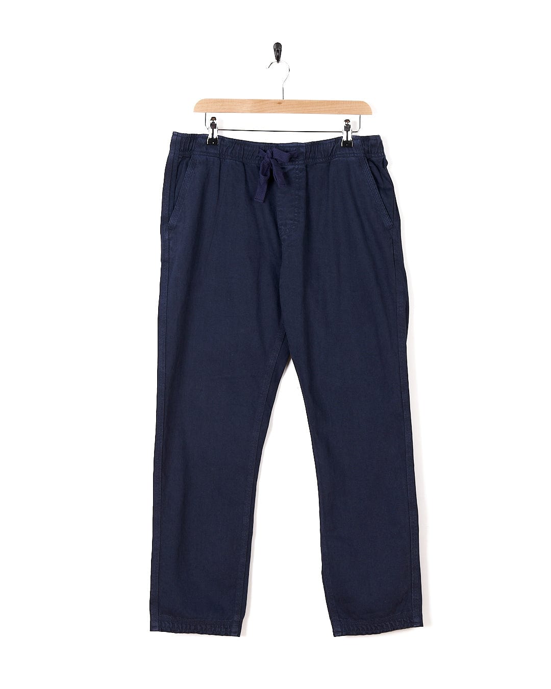 A pair of Meddon - Mens Twill Trouser - Blue pants hanging on a hanger, by Saltrock.