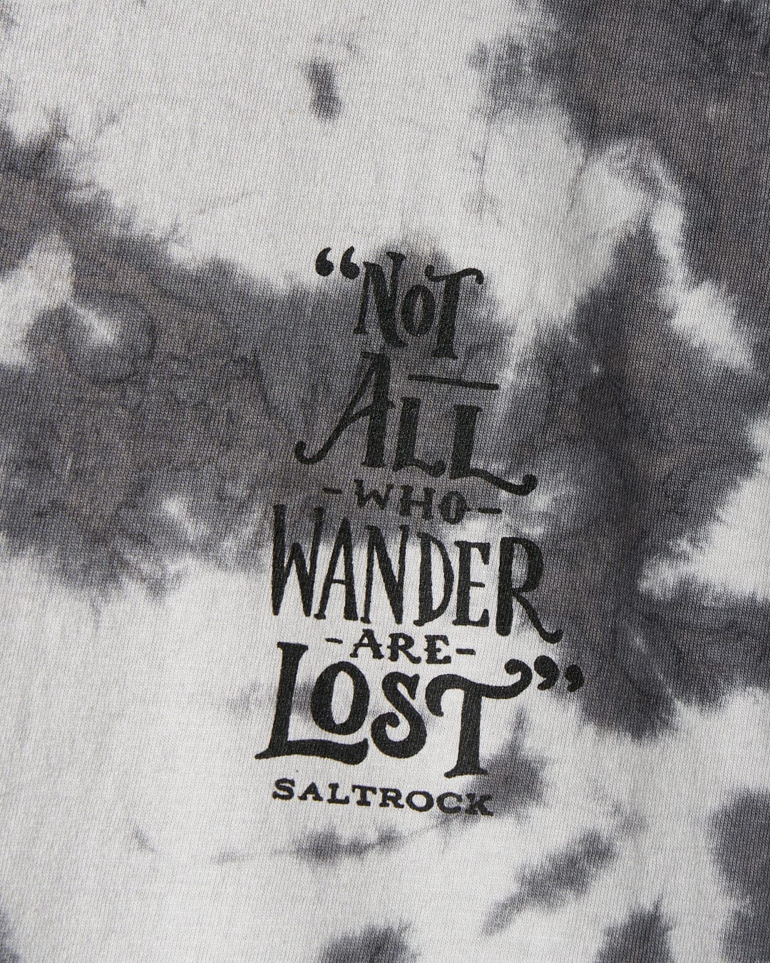 A close-up of the Lost Ships men's grey tie dye T-shirt by Saltrock shows the printed quote: "Not all who wander are lost," with the Saltrock logo beneath.