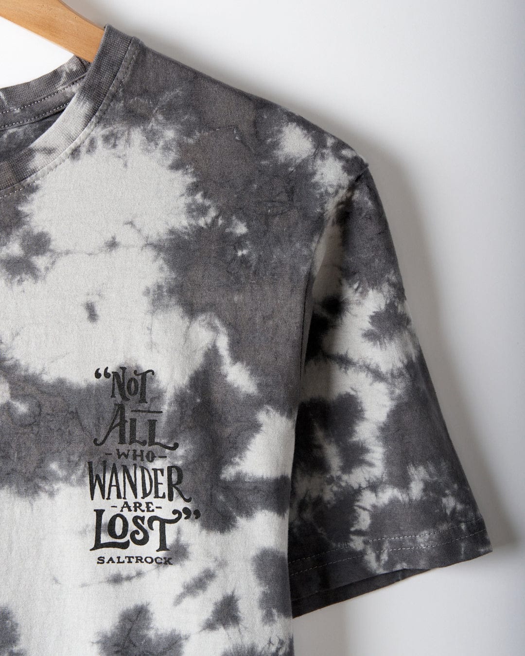 Grey cotton tie dye t-shirt, Lost Ships by Saltrock, on a hanger with the printed text "Not all who wander are lost.