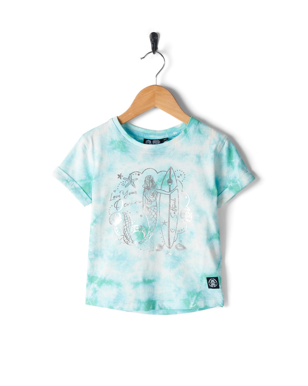A blue and white tie-dye Saltrock Mermaid Surf - Kids T-Shirt - Turquoise/White on a hanger featuring a 100% cotton fabric with a mermaid print holding a surfboard and the text "Love you, Ocean.