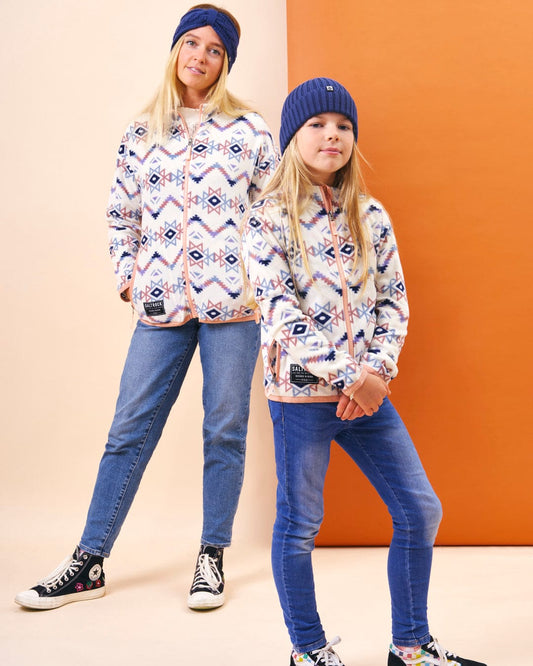 A girl and a boy wearing Saltrock's Micro Ida - Kids Zip Fleece - Cream jackets with Aztec print design, featuring Saltrock branding.