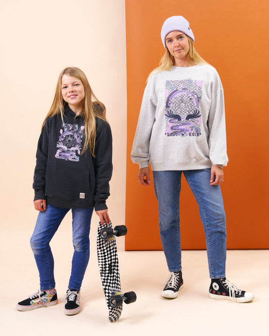 A girl and a boy, dressed in cozy Saltrock Cosmic Soul - Kids Hoodie - Dark Grey Hoodies, standing next to a skateboard during an outdoor adventure.