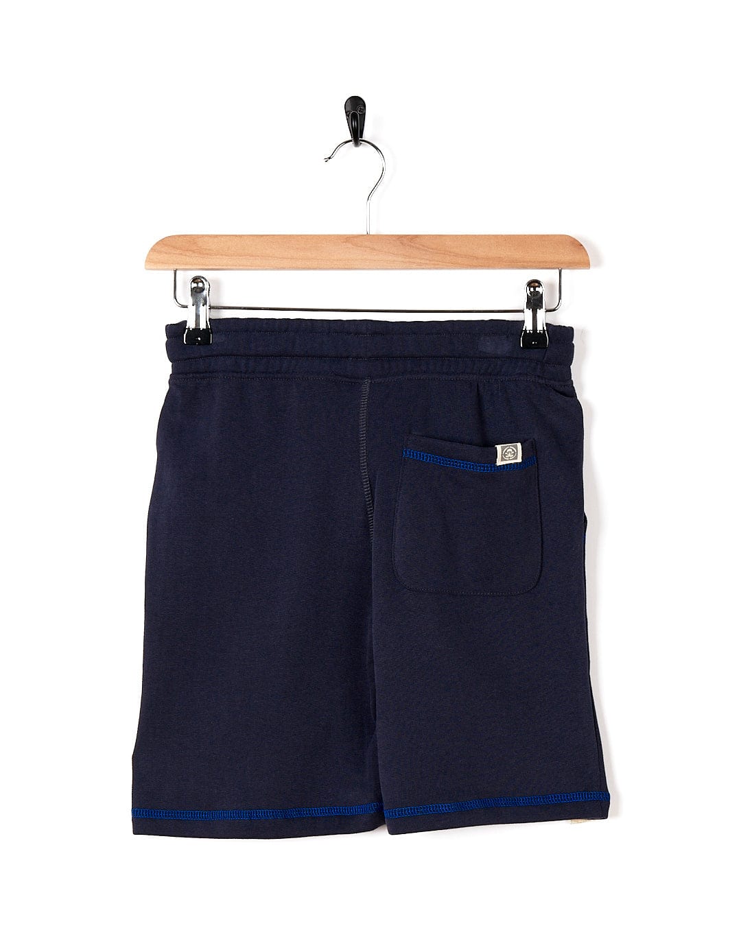 A boy's Morte Point - Kids Sweat Shorts - Blue hanging on a hanger, Saltrock.
