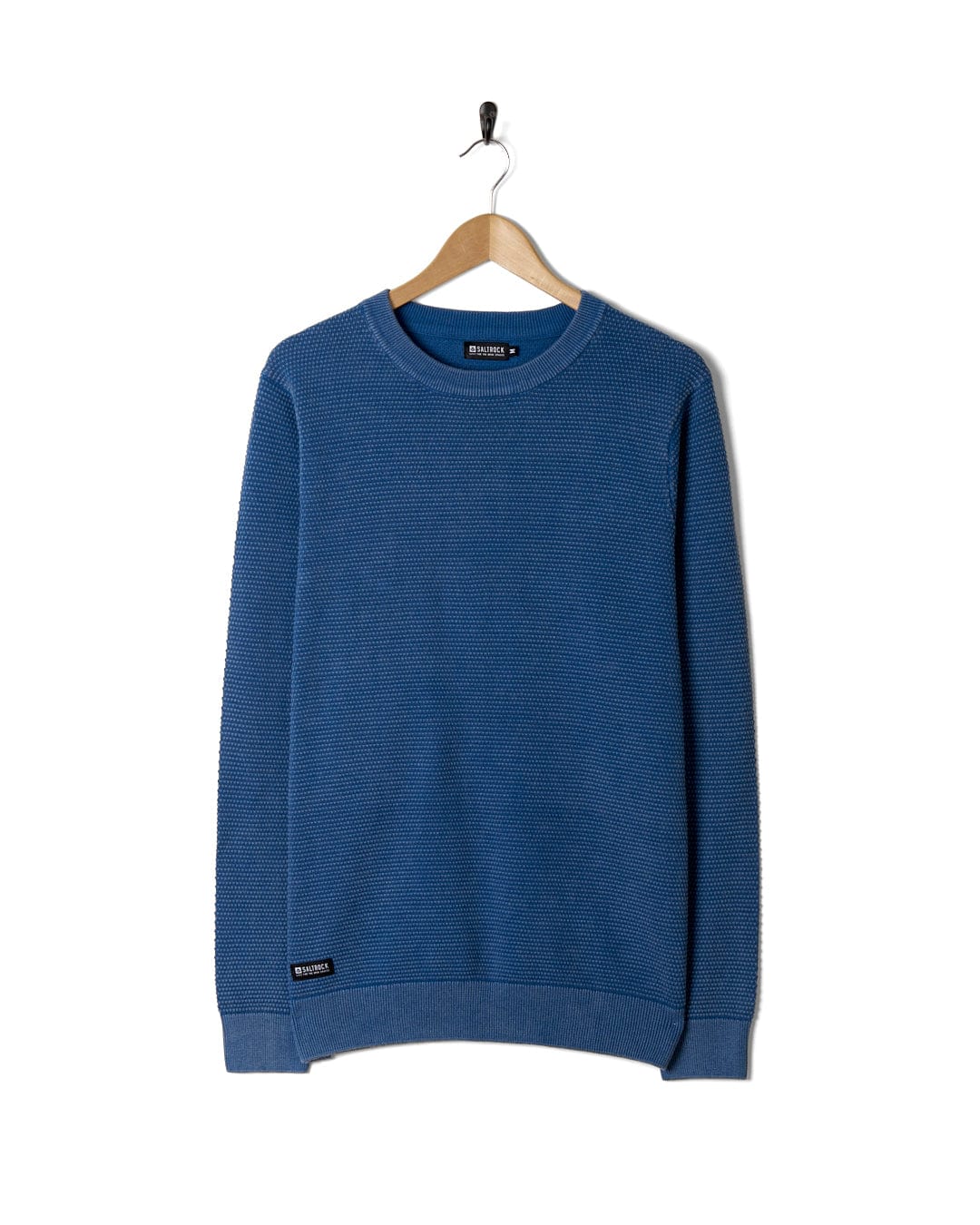 A Saltrock Moss - Mens Washed Knitted Crew sweatshirt hanging on a hanger.