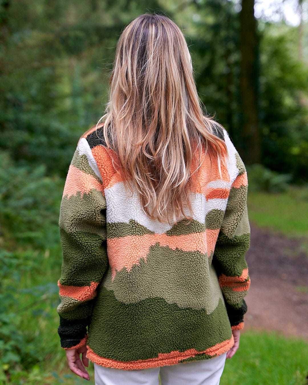 The back of a woman wearing a Saltrock Mountain Scape - Womens 1/4 Fleece - Orange sweater.