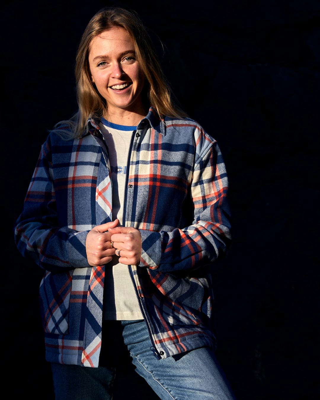 A young woman wearing a Saltrock Myla - Womens Hooded Checked Shacket - Blue Check with front pockets.