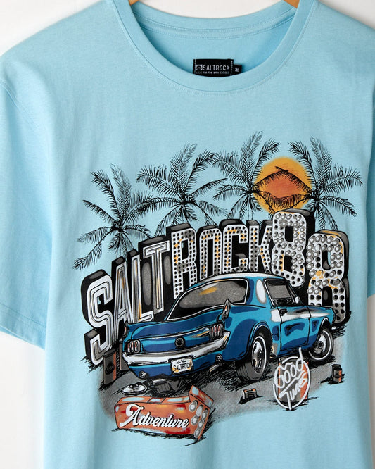 A soft peached fabric blue Neon Boneyard - Mens Short Sleeve T-Shirt featuring a graphic print with a vintage car, palm trees, sunset, and the text "Saltrock 89 adventure" on the front.