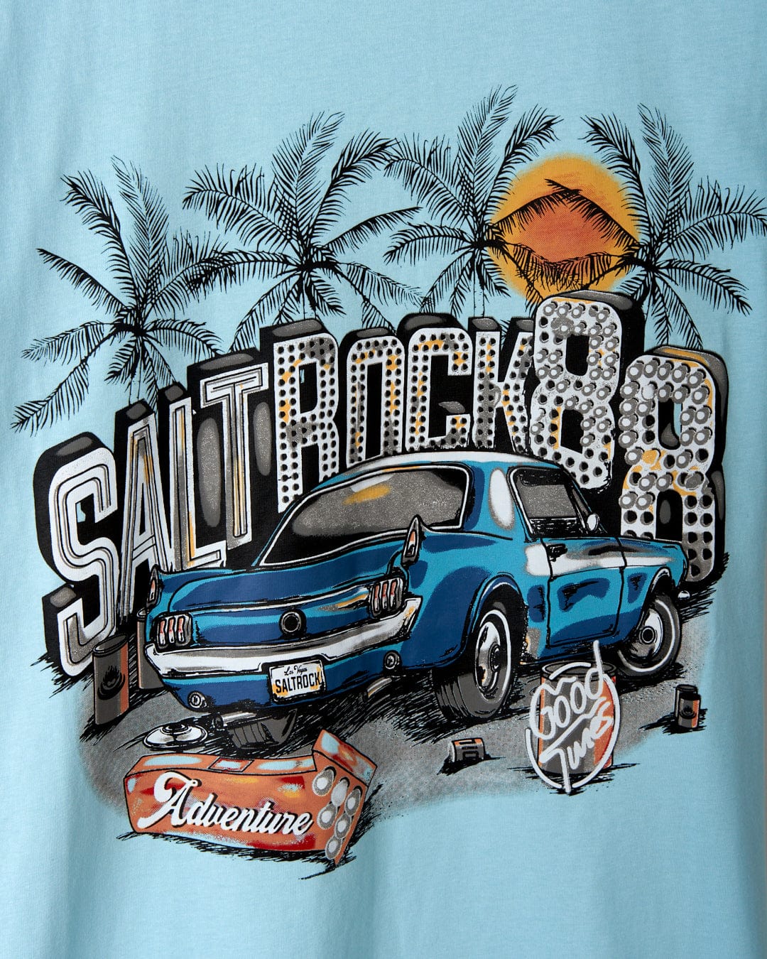 Graphic print on a blue cotton Neon Boneyard t-shirt by Saltrock featuring the text "Saltrock 88," a vintage car illustration, palm trees, a setting sun, and additional decorative elements with adventure and surfing themes.