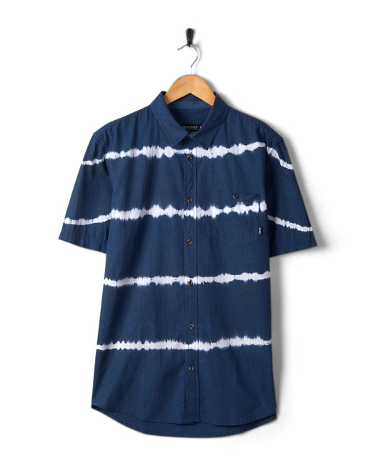 A Saltrock Ocean - Mens Tie Dye Shirt in Blue hanging on a coat hanger against a white background.