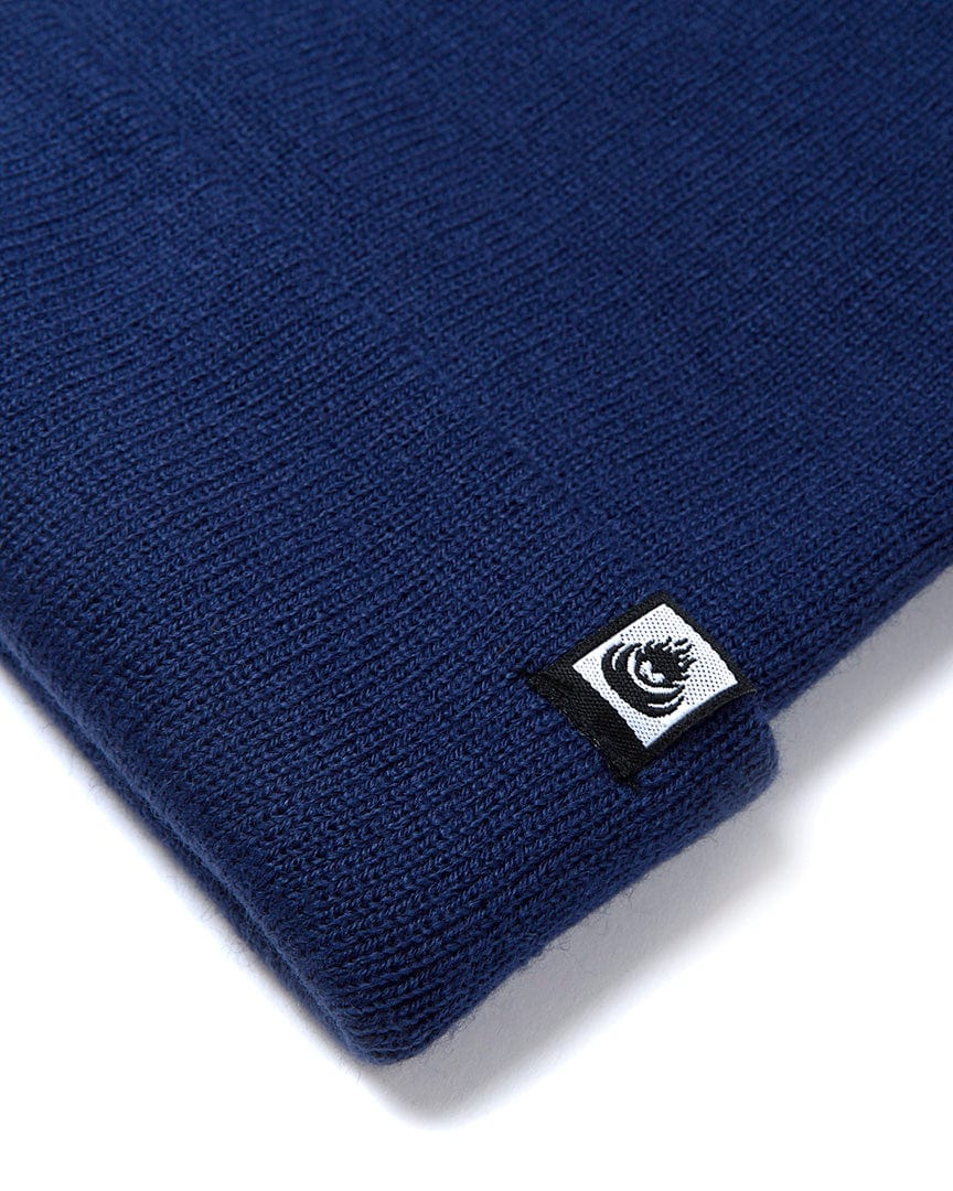 A Ok - Tight Knit Beanie - Dark Blue with a Saltrock logo on it.