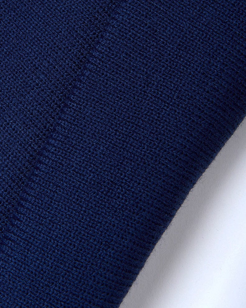A close up of a Saltrock Ok - Tight Knit Beanie - Dark Blue on a white surface.