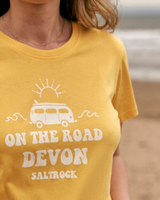 A woman wearing a yellow Saltrock t-shirt that says On The Road Devon.