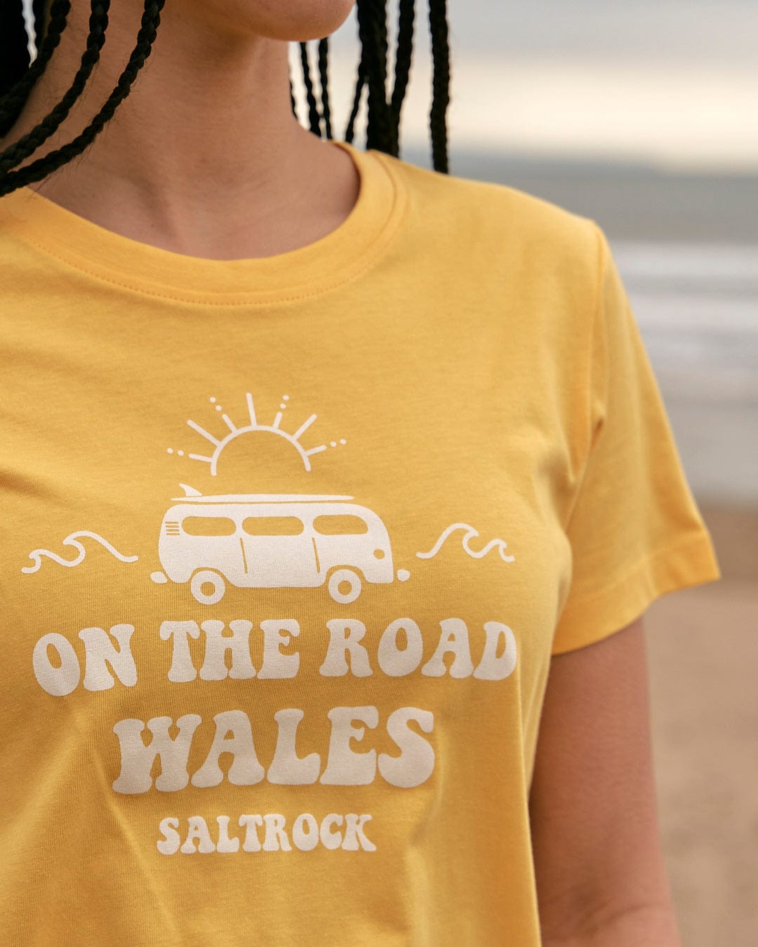 A woman wearing a Saltrock yellow On The Road Wales - Womens Short Sleeve T-Shirt.