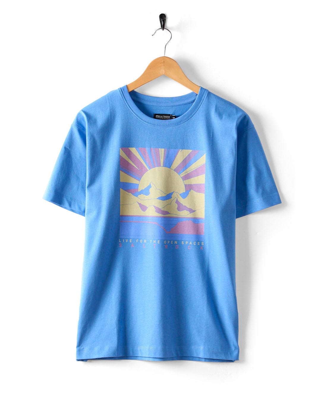 The Saltrock "Open Spaces" women's oversized blue T-shirt features a captivating mountains and sun graphic with rays, accompanied by the phrase "LIVE FOR THE OPEN SPACES.