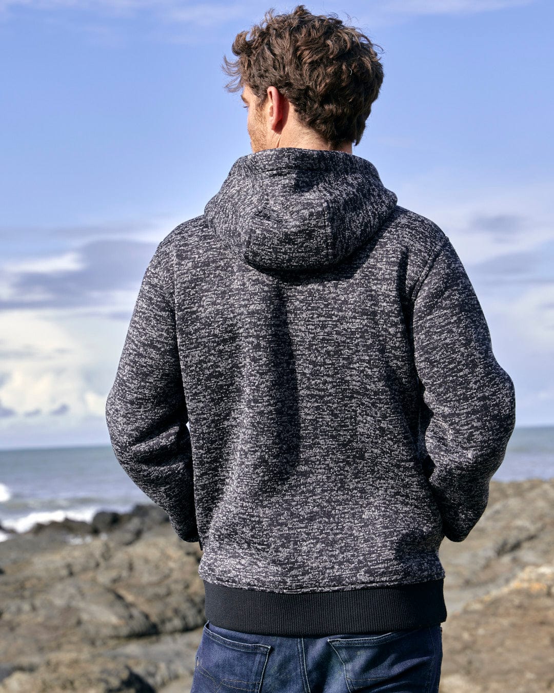 The back of a man wearing a Saltrock Oskar - Mens Bonded Zip Hoodie - Grey admiring the ocean.