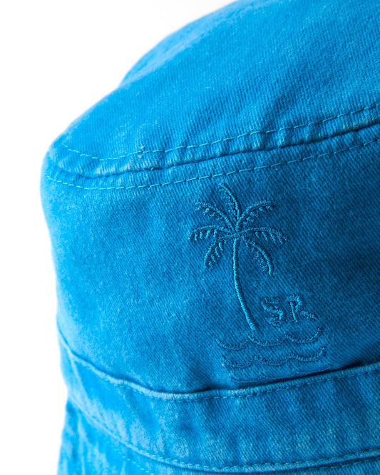 Close-up of a cotton fabric with an embroidered palm tree and anchor design on the Palm Bucket Hat - Blue by Saltrock.
