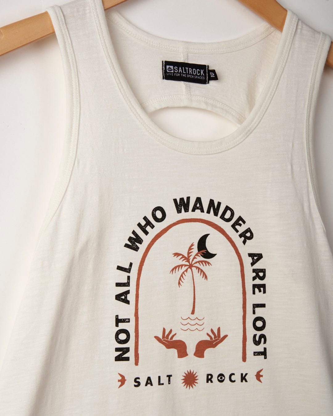 Saltrock Palmera - Womens Vest - White featuring "not all who wander are lost" print, with palm tree and wave graphics, displayed on a wooden hanger.