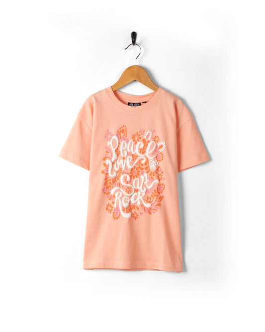 Saltrock Peach cotton t-shirt with "peace love rock" graphic design, hung on a hanger against a white background.
