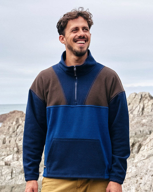 A man wearing a Saltrock Peninsula - Mens 1/4 Zip Pullover Fleece - Blue, showcasing his style in activewear.