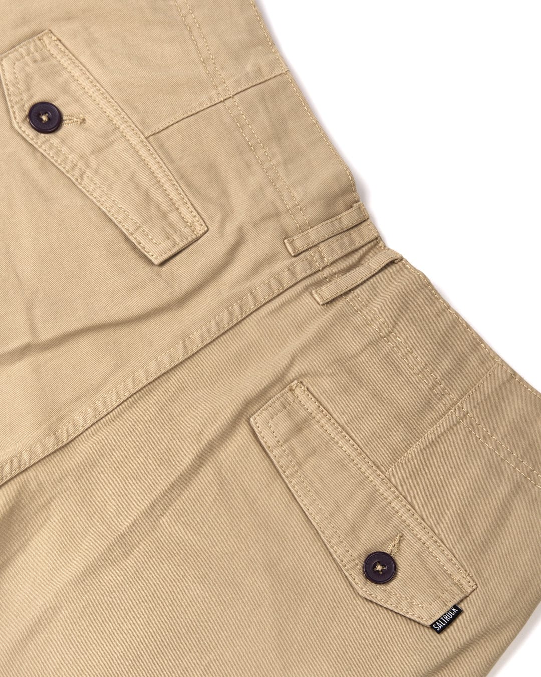 Close-up of Saltrock Penwith II - Mens Cargo Shorts - Cream with buttoned pockets and belt loops, focusing on the texture and details of the cotton material.