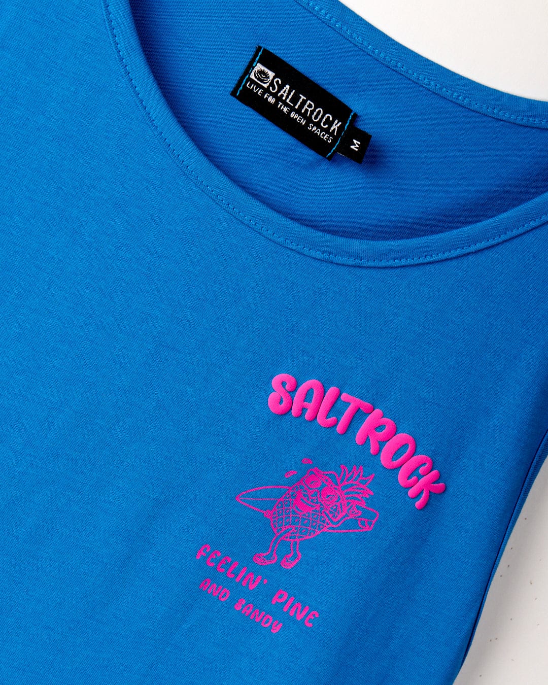 Blue "Saltrock" sleeveless cotton shirt named "Pine And Sandy - Mens Vest," featuring a pink pineapple graphic with the text "Feelin' Pine and Sandy.