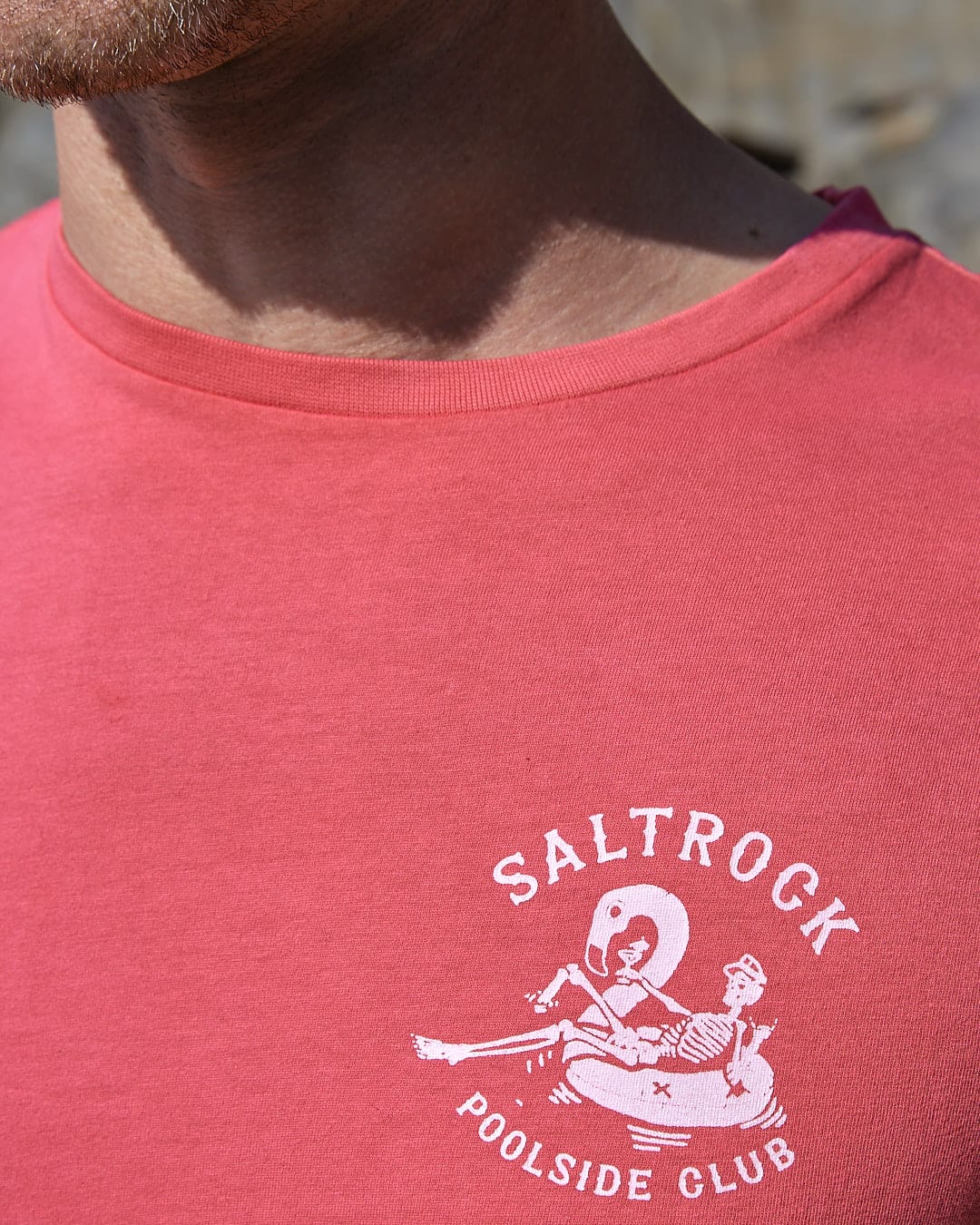 A man wearing a red t-shirt with the Saltrock brand logo on it.