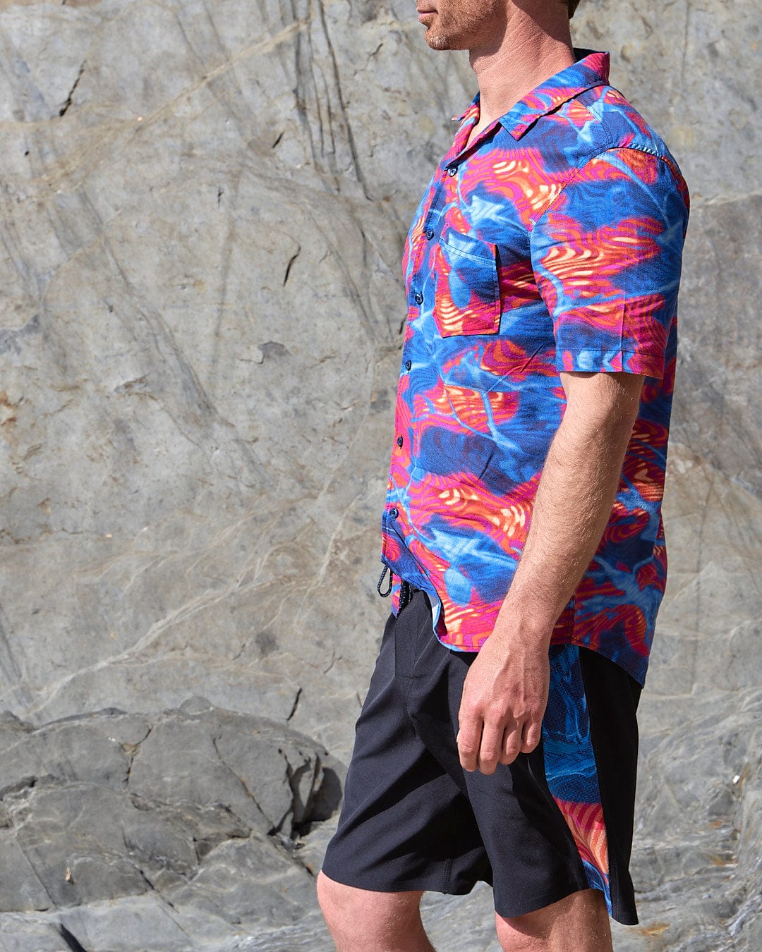 A man in a Saltrock Poolside Panel - Mens Recycled 4-Way Stretch Boardshort - Black shirt.