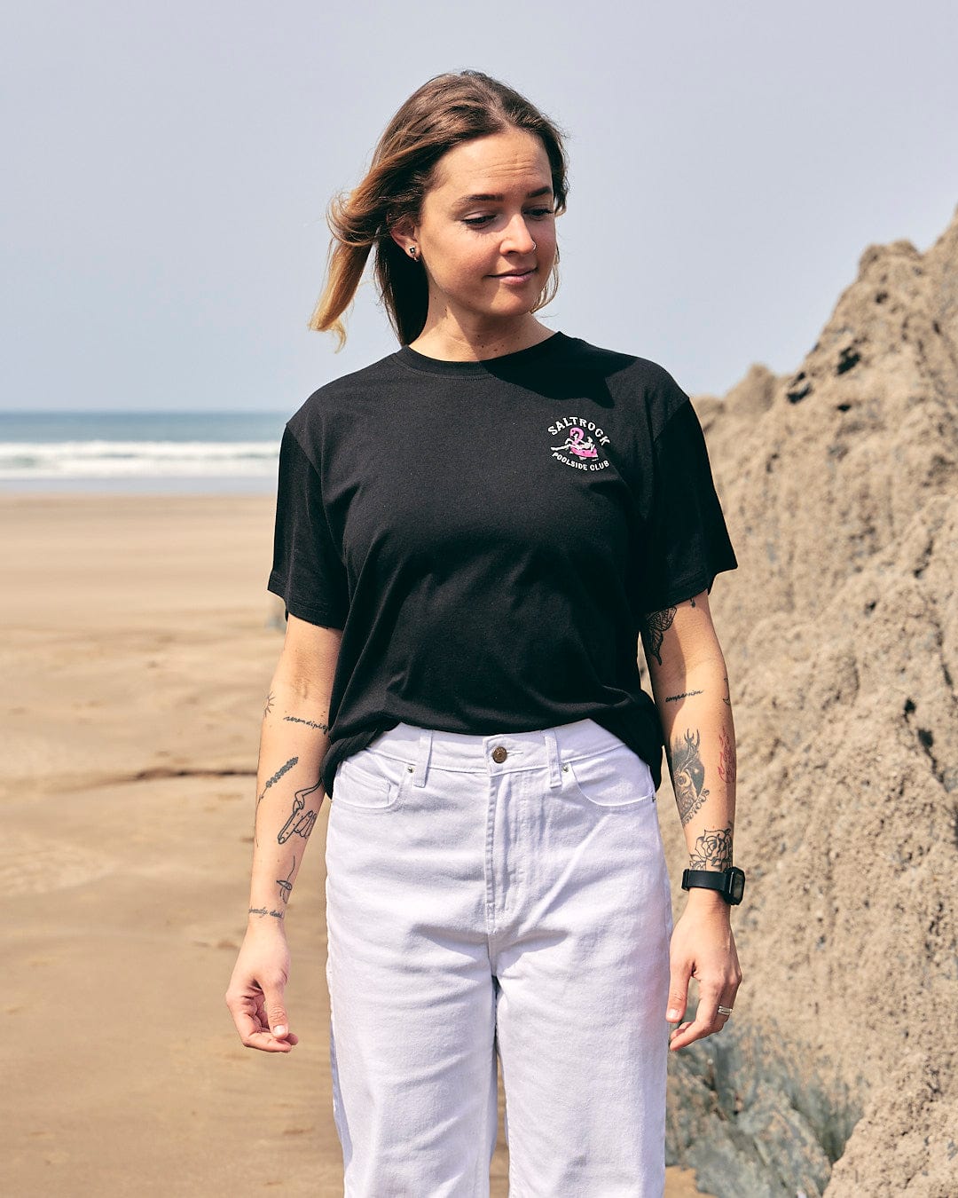A woman standing on the beach wearing a Saltrock - Poolside Womens Short Sleeve T-Shirt - Black.