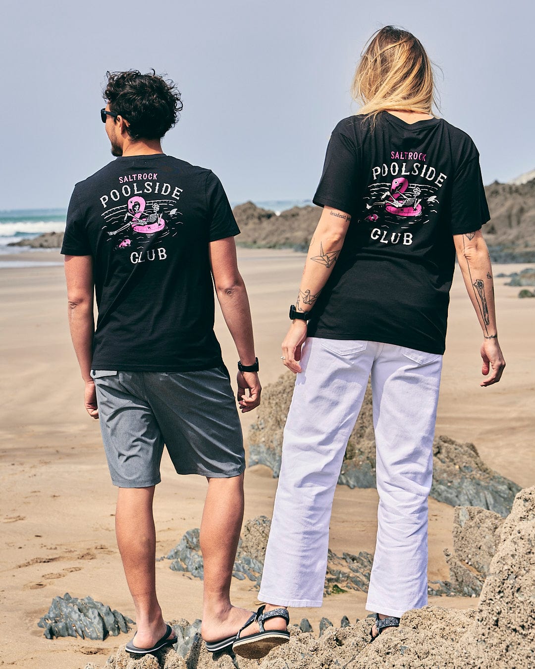 Two people standing on the beach wearing Saltrock's Poolside - Womens Short Sleeve T-Shirt in Black.