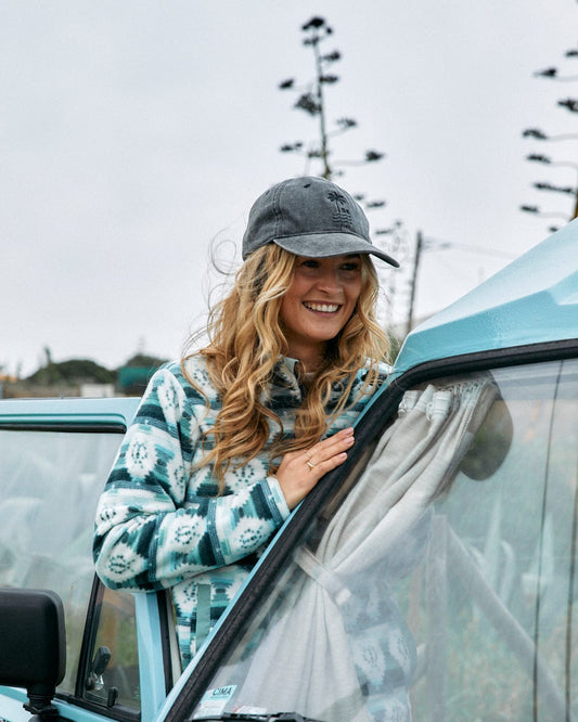 A blonde woman is leaning out of the window of a blue car in a Saltrock Portis - Womens Fleece - Green material.