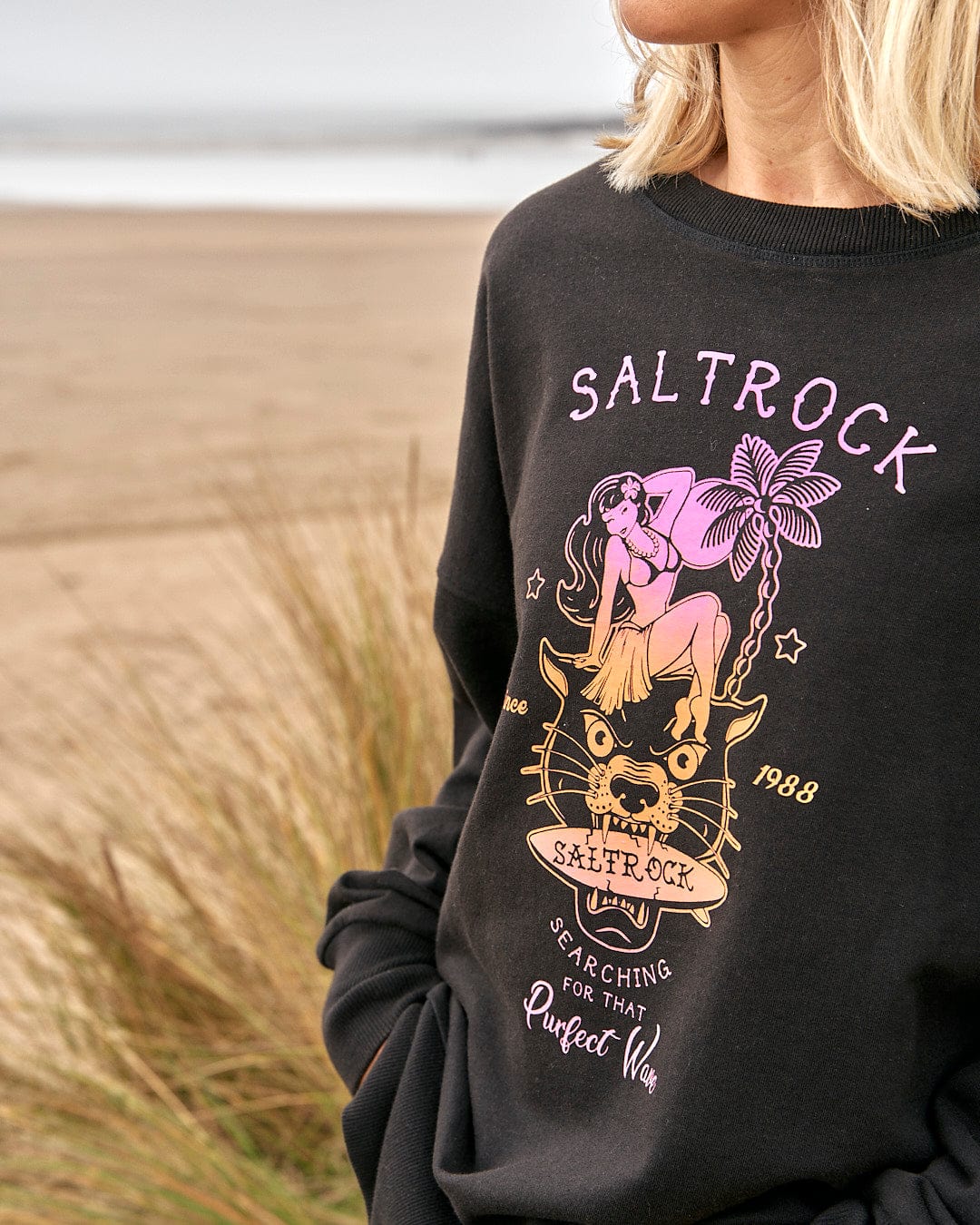 A woman wearing a Purfect Wave Gradient - Womens Boyfriend Fit Sweat - Black sweatshirt by Saltrock.