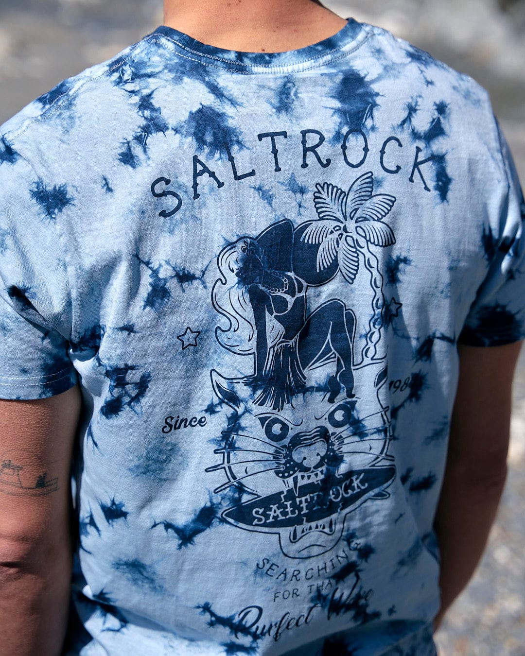 The back of a man wearing a Saltrock Purfect Wave - Mens Tie Dye Short Sleeve T-shirt - Light Blue.