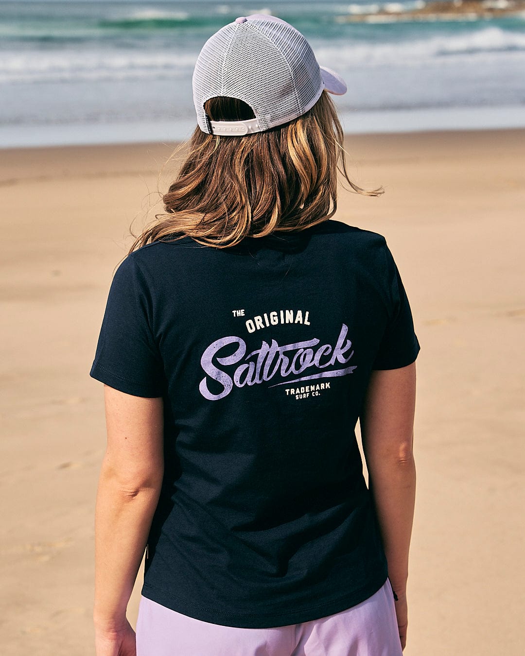 the back of a woman standing on the beach wearing a Saltrock - Womens Short Sleeve T-Shirt - Navy.