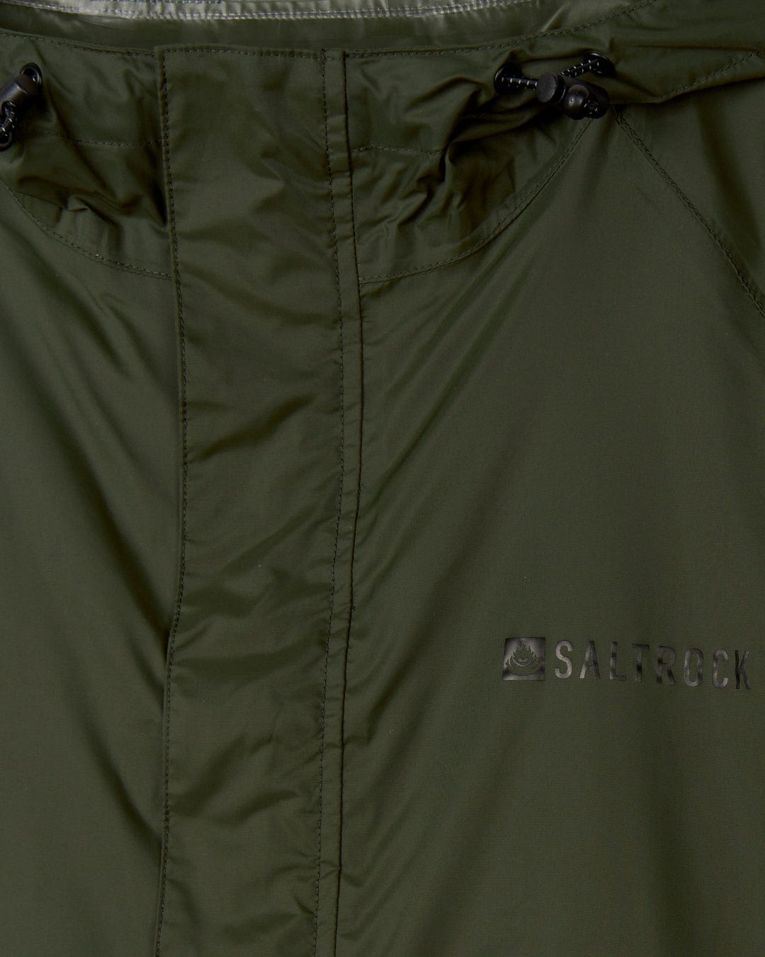 Close-up of a green Rainier - Mens Packable Waterproof Jacket showing the texture, zipper detail, and embroidered Saltrock logo.