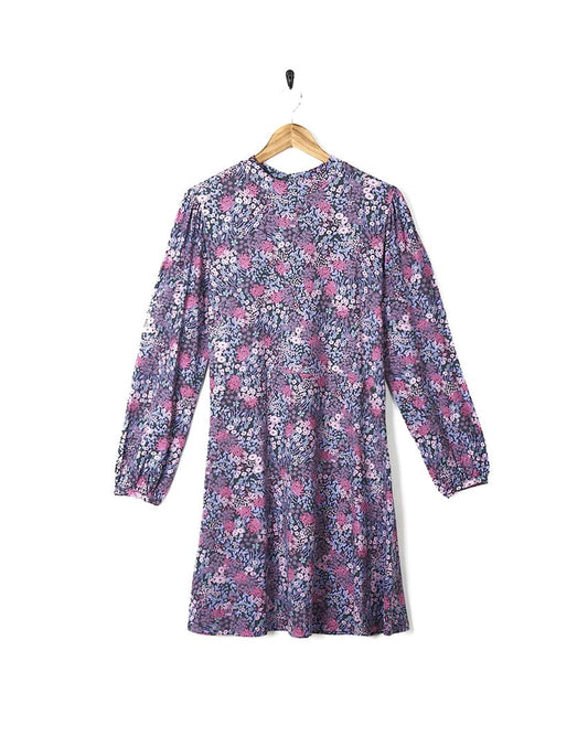 A Saltrock Ramona Womens Mock Jersey Dress - Purple in a purple and pink print hanging on a wooden hanger.