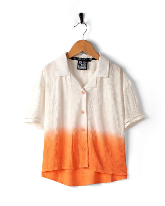A Saltrock Raya - Kids Shirt - Orange hanging on a black hanger against a white background.