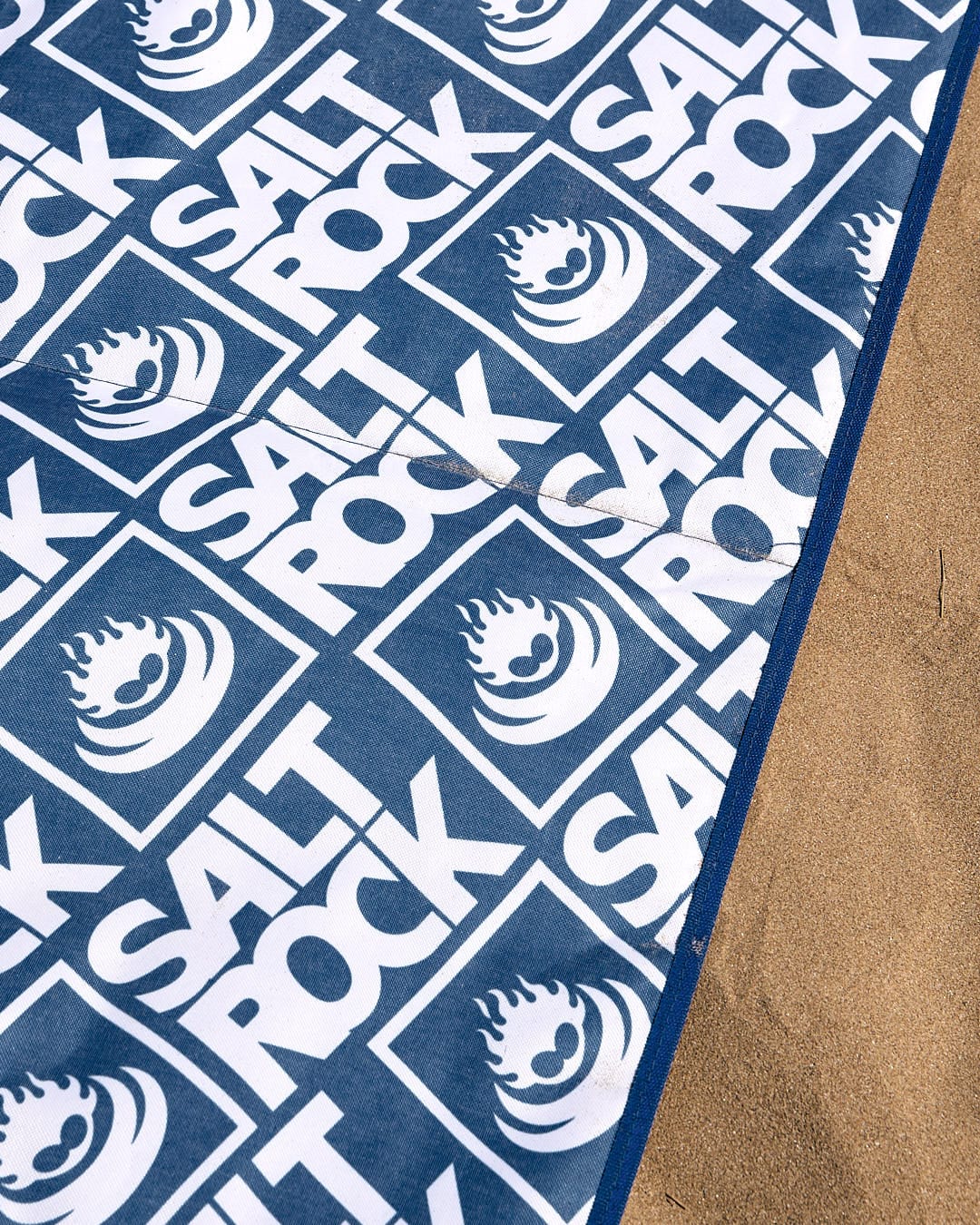 A comfortable Relax - Beach Mat - Blue with the Saltrock logo on it.