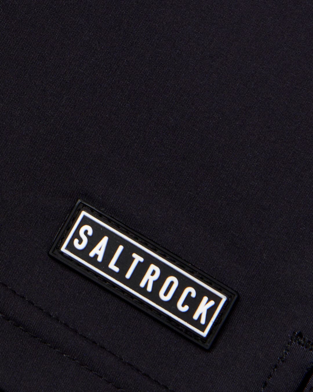 A close up of Retro Ribbon - Womens Boardshorts - Black with the word Saltrock on it made from Repreve recycled material.