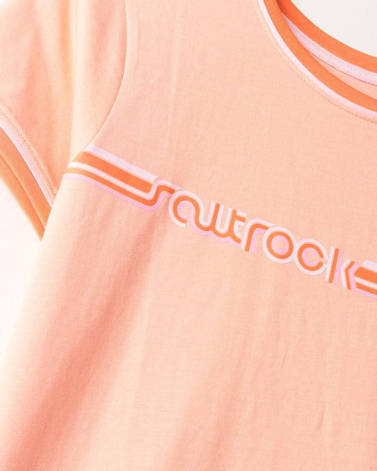 Close-up of a Saltrock peach-colored Retro Ribbon - Womens Shorts Sleeve T-Shirt with the word "squrocket" in white font outlined with pink and retro stripes on the chest area.